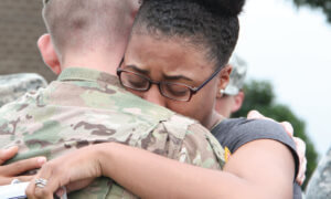 Young woman hugs her Army solider husband