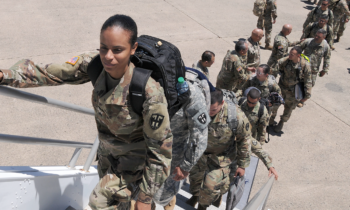 Service members board a plane